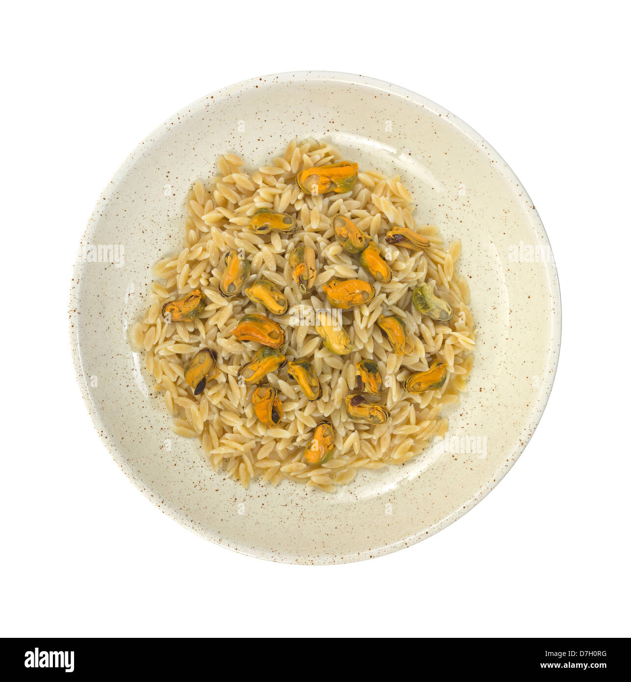 Top view of a serving of orzo topped with marinated mussels in shallow bowl on a white background. Stock Photo