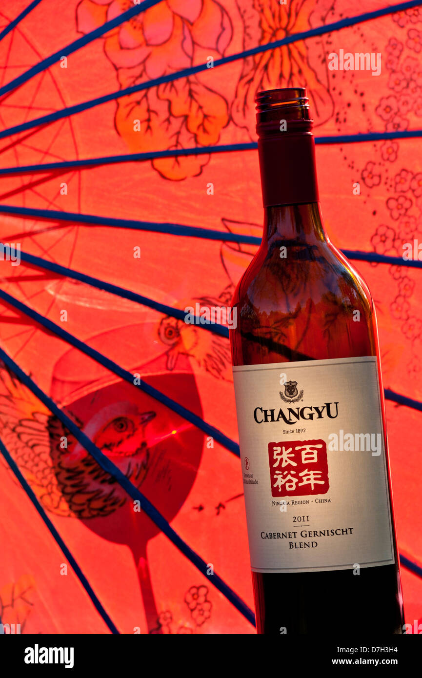 Bottle of 2011 Chinese 'Changyu' Cabernet Gernischt red wine from Ningxia region China with oriental umbrella and glass shadow Stock Photo