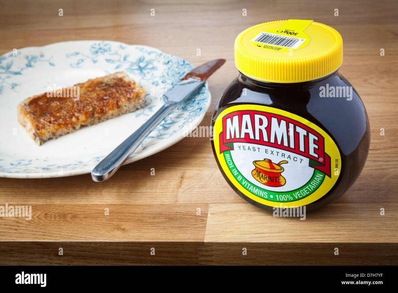 Bath, UK - September 25, 2011: A pot of Marmite on a wooden kitchen surface with toast in the background. Stock Photo