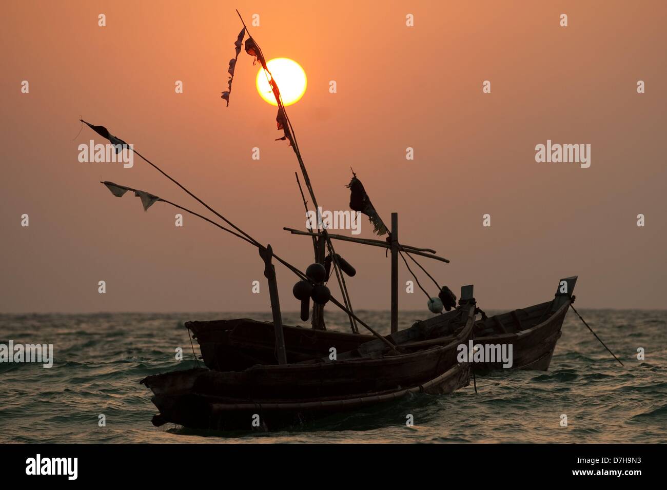 Two fishing boats are pictured during sunset at Ngapali Beach, Myanmar, 08 April 2013. Photo: Sebastian Kahnert Stock Photo