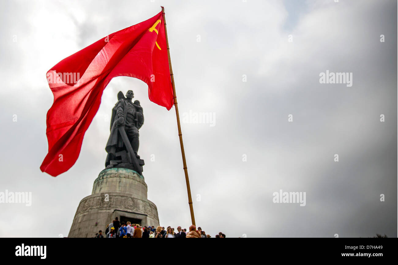 A red Soviet flag waves at the Soviet War Memorial while visitors are lining up to lay flowers and wreaths to commemorate the end of World War II on 08 May 1945, in Berlin, Germany, 08 May 2013. The memorial is dedicated to the fallen World War II soldiers of the Red Army. Photo: HANNIBAL Stock Photo