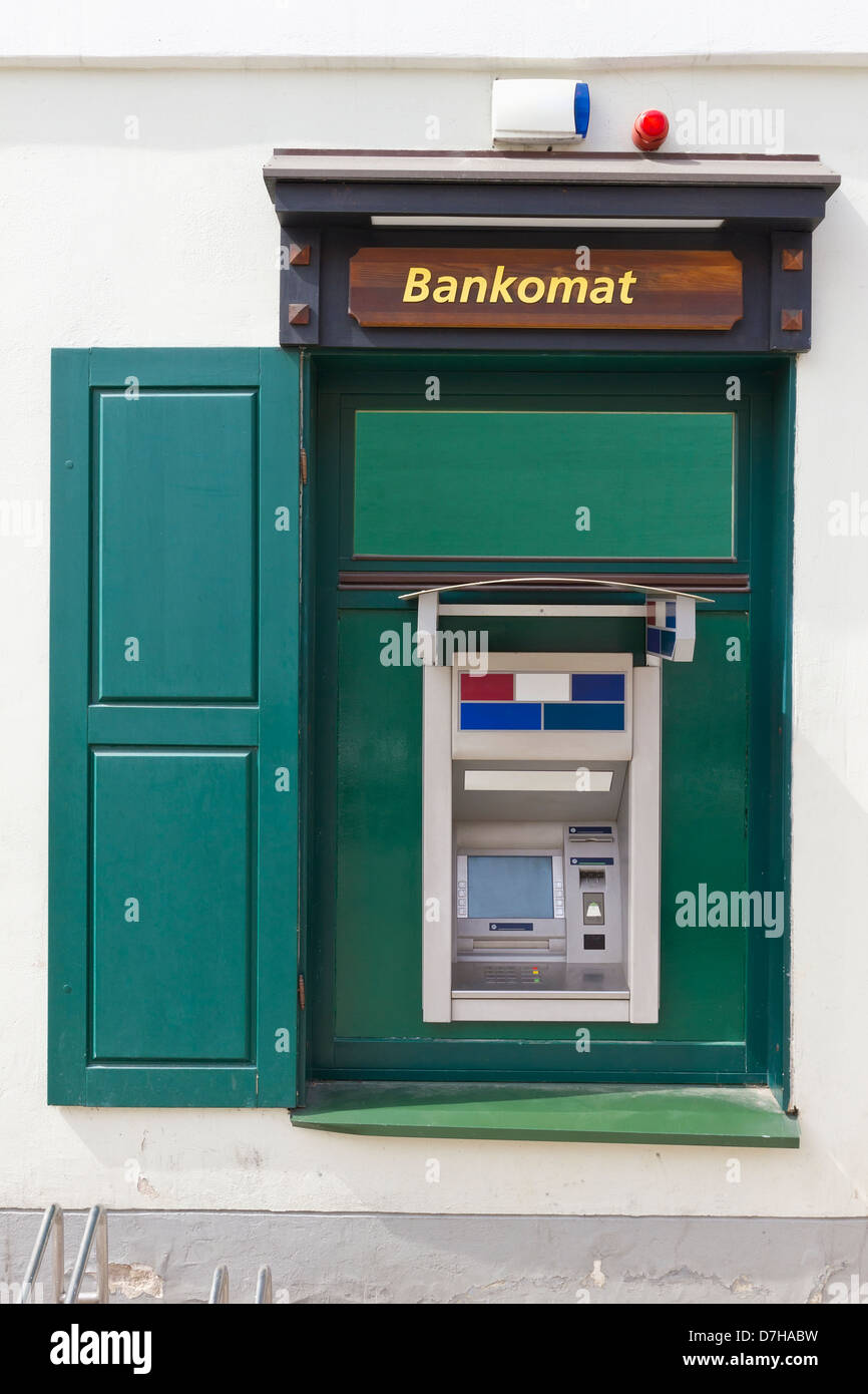 The green street money ATM cash dispense mass production device is established in a window of the apartment house Stock Photo