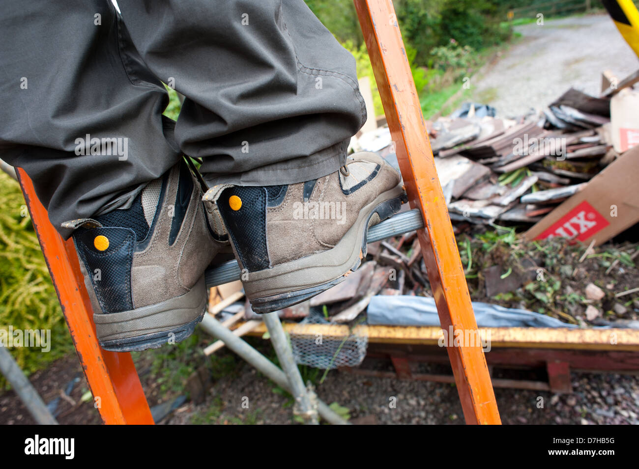 A builder climbing a ladder Stock Photo