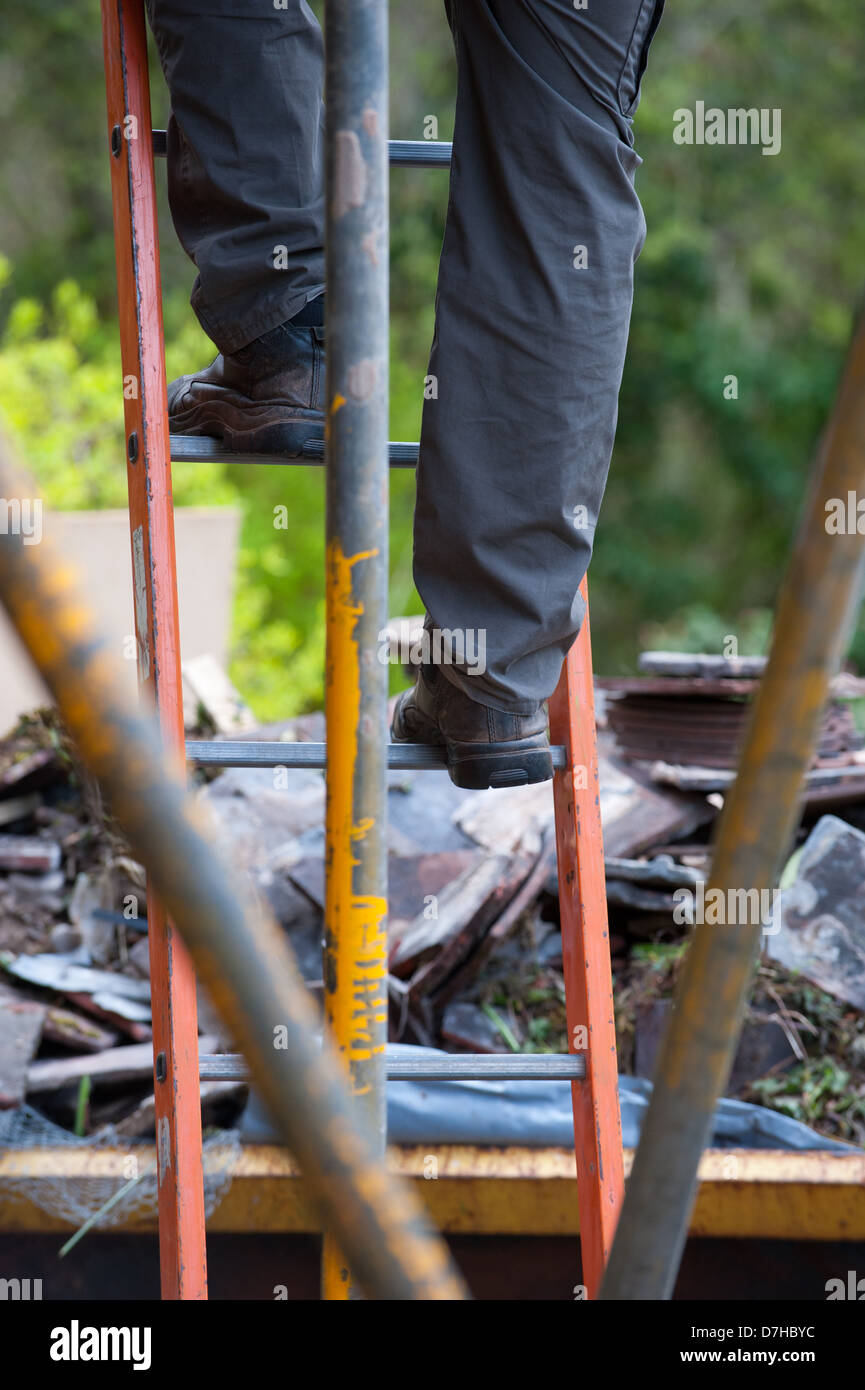 A builder climbing a ladder Stock Photo