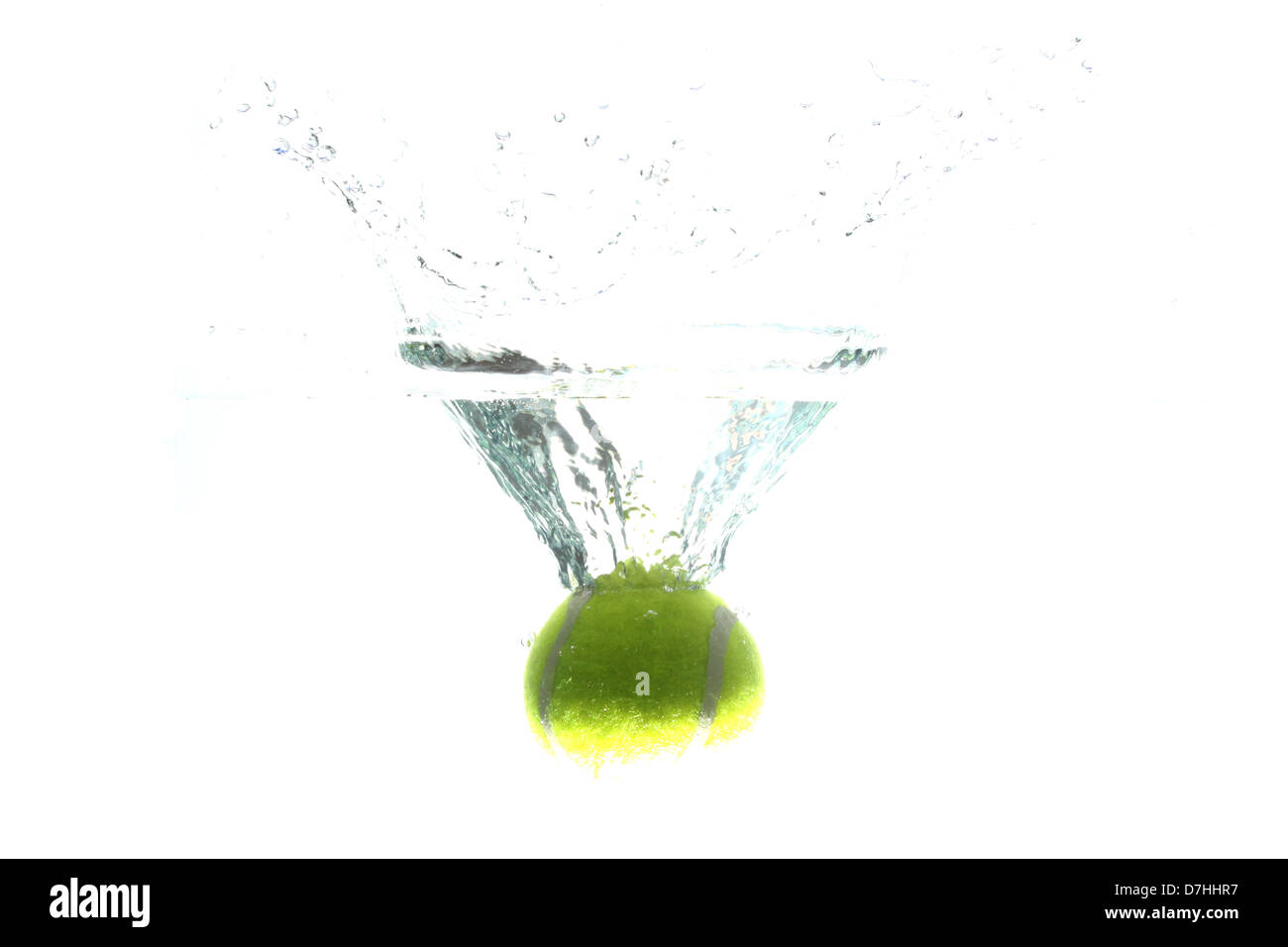 Tennis ball dropped into the water, causing spread water. Stock Photo