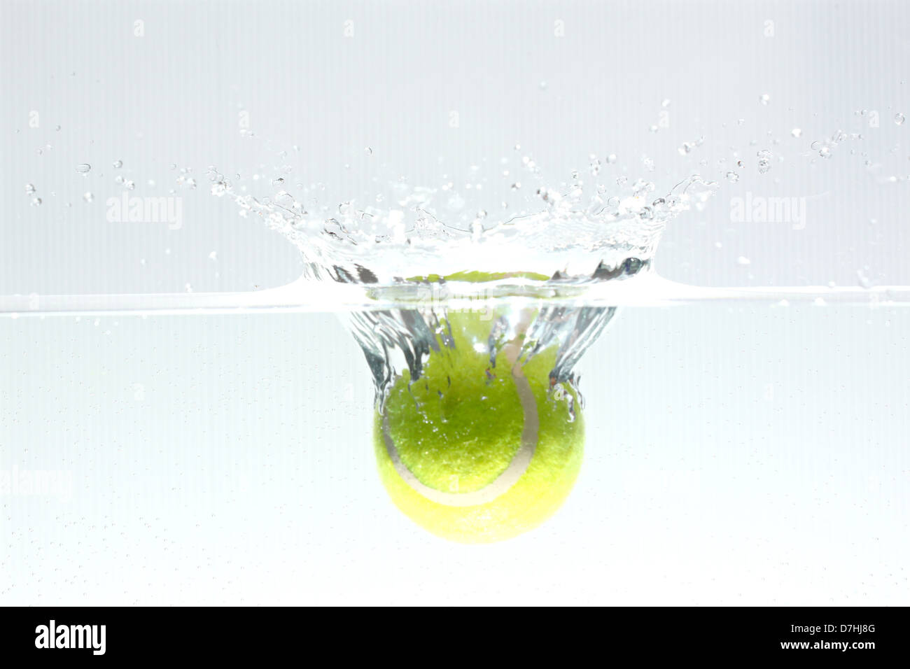 Tennis ball dropped into the water, causing spread water Stock Photo