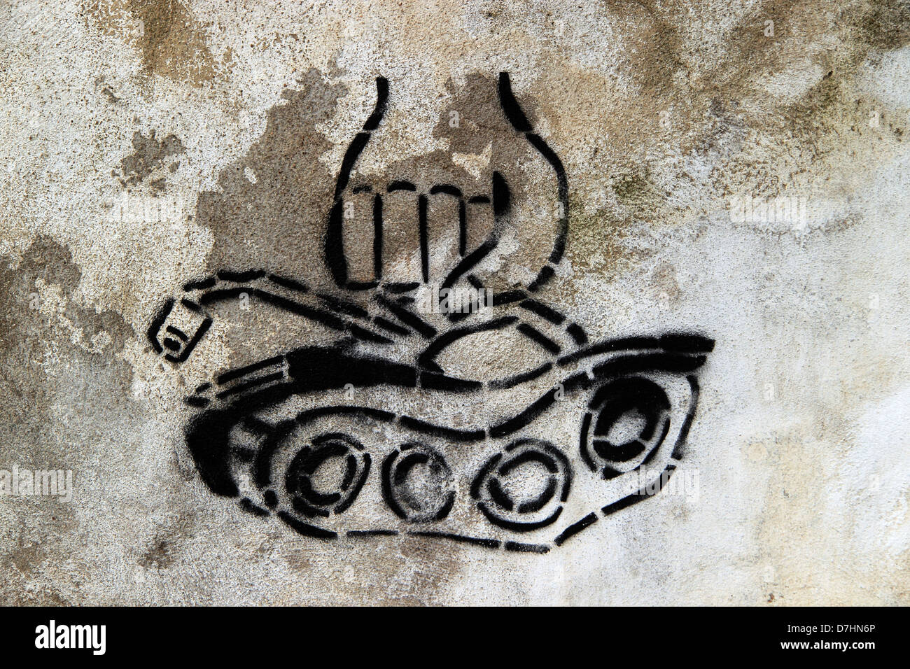 Political graffiti, stencil on a wall of a fist crushing a tank, Lisbon, Portugal Stock Photo