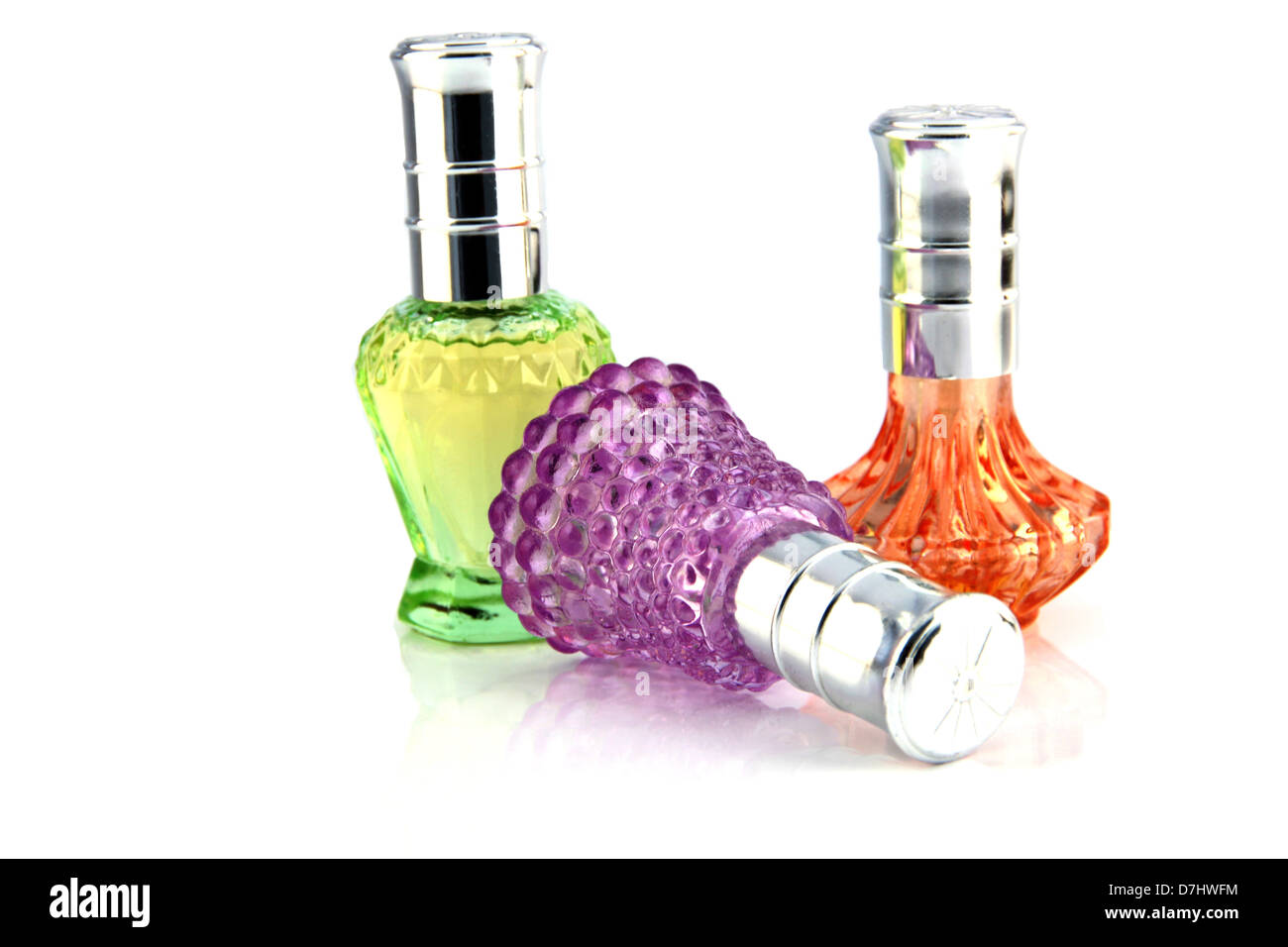 Three colors Perfume bottle resting on a white background. Stock Photo