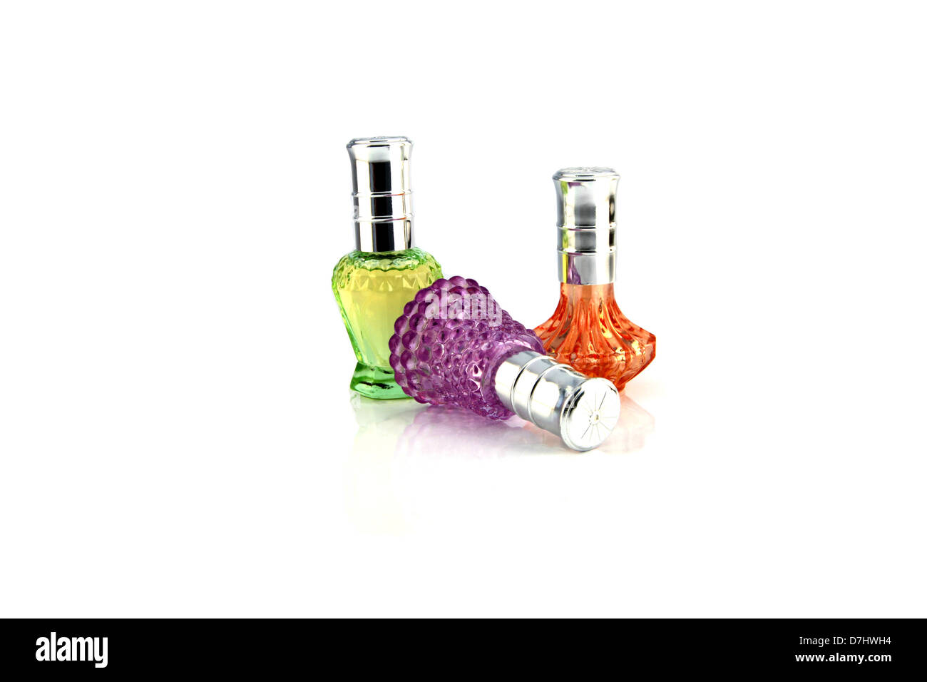 Three colors Perfume bottle resting on a white background. Stock Photo