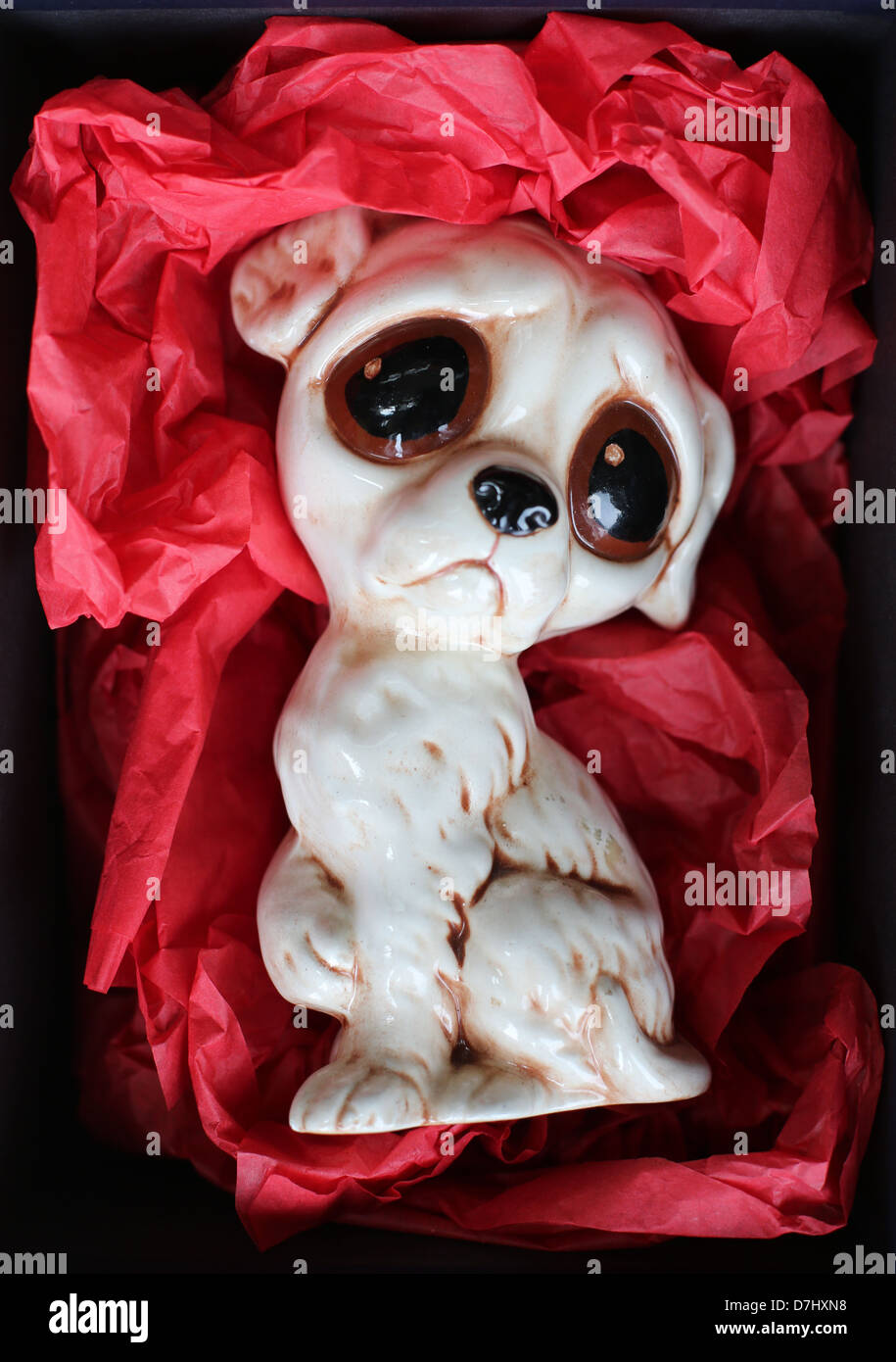 A gift box containing a figurine of a sad puppy. Stock Photo