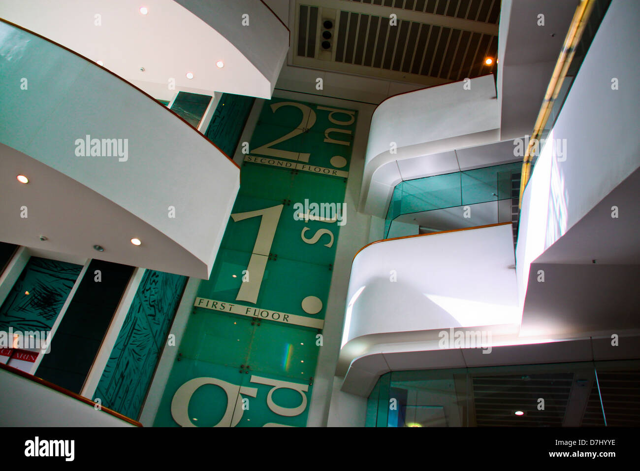 Escalators floor signs and balconies in shopping centre Stock Photo - Alamy