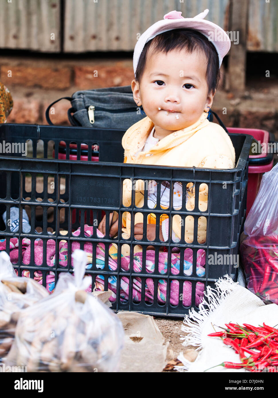 Baby in the basket, Kyaing Tong market, Burma (Myanmar) Stock Photo