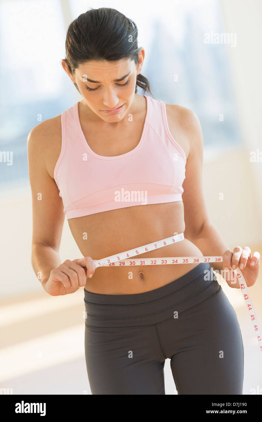 Slim woman measuring her thin waist Stock Photo by ©stockasso 80139016