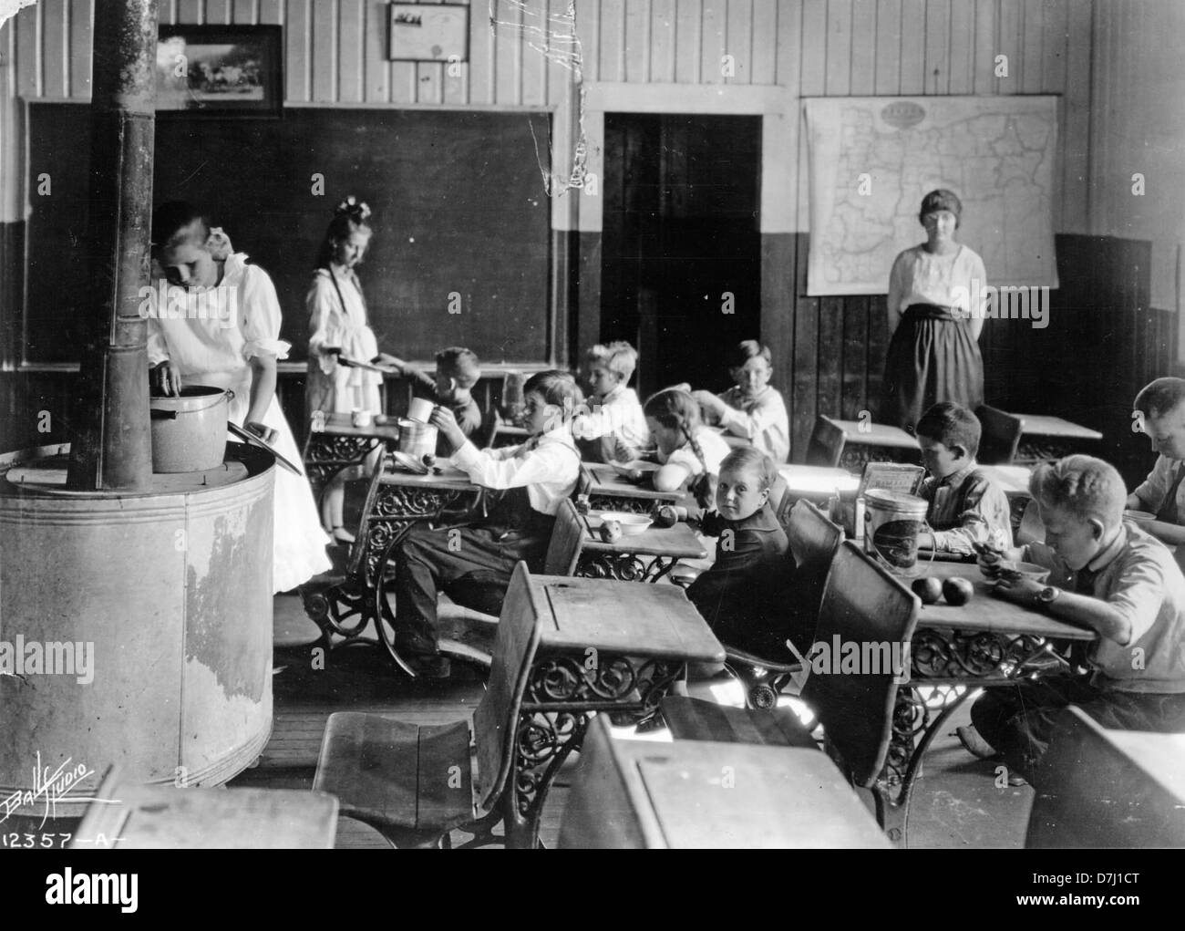This photograph depicts individuals eating lunch at their desks, a scene often associated with office culture, showing how work environments shape daily routines and social interaction in contemporary settings. Stock Photo