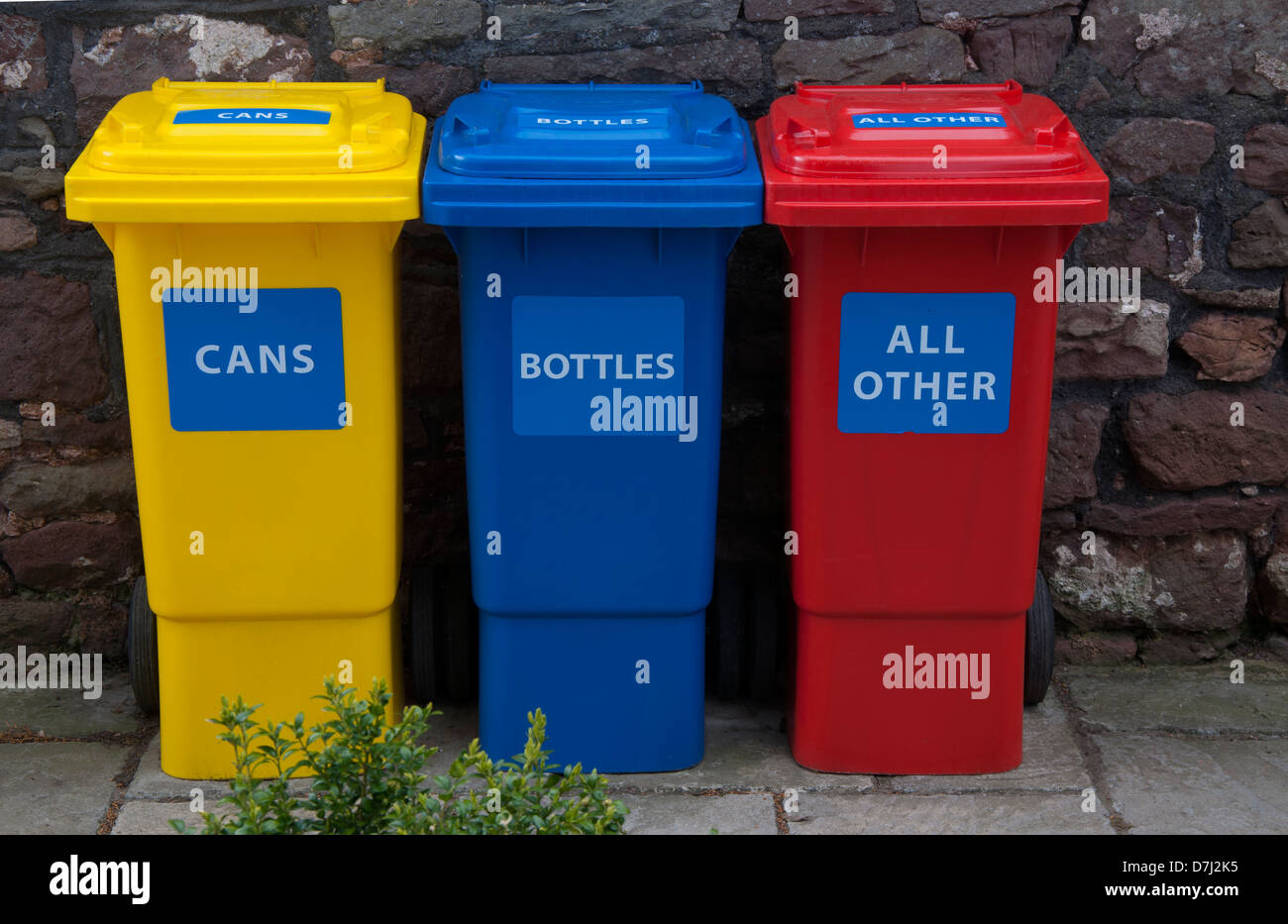 recycling bins, coloured, yellow, red,blue, three, against stone wall