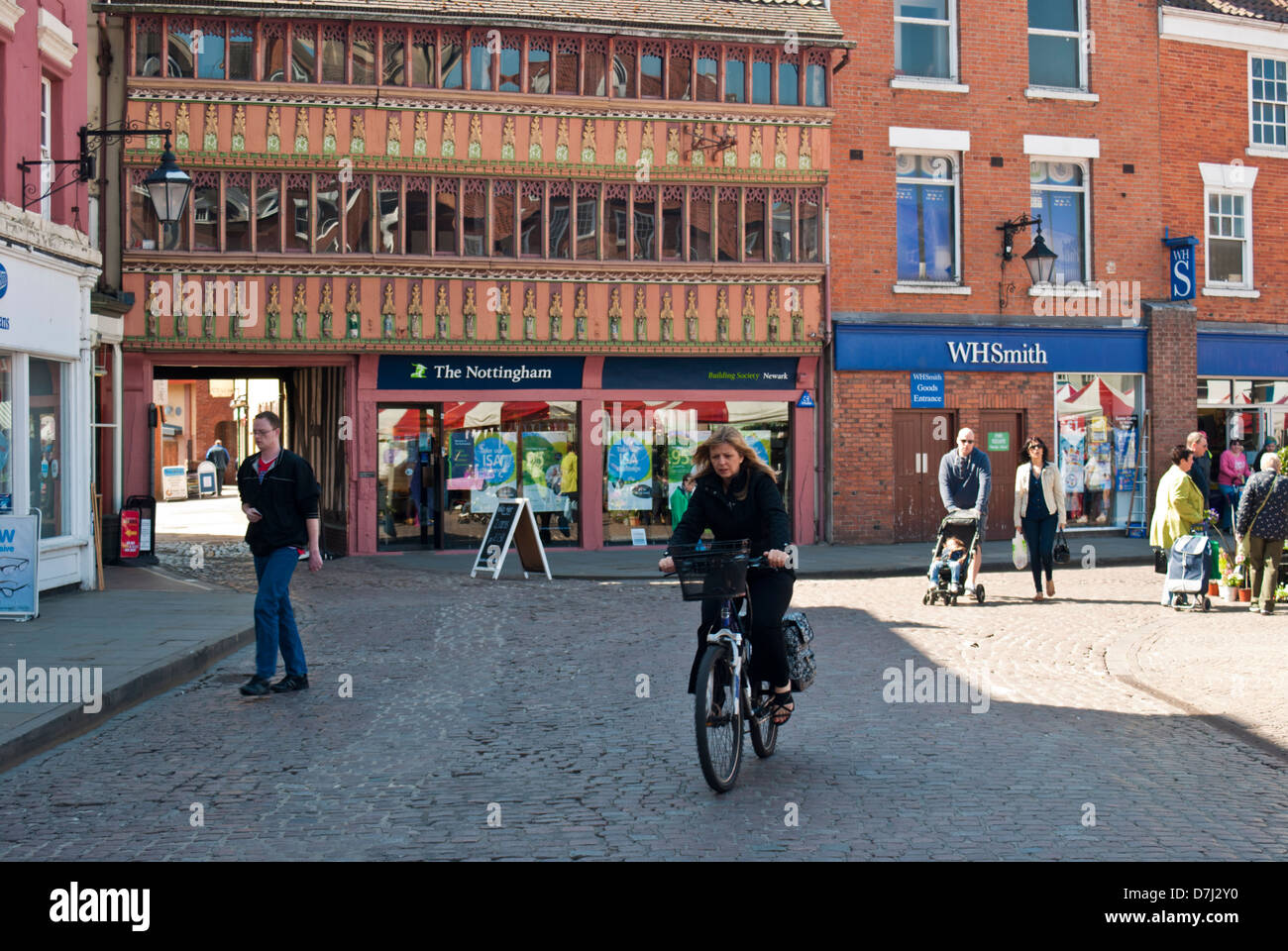 Young woman riding a bicycle in Newark town centre Stock Photo