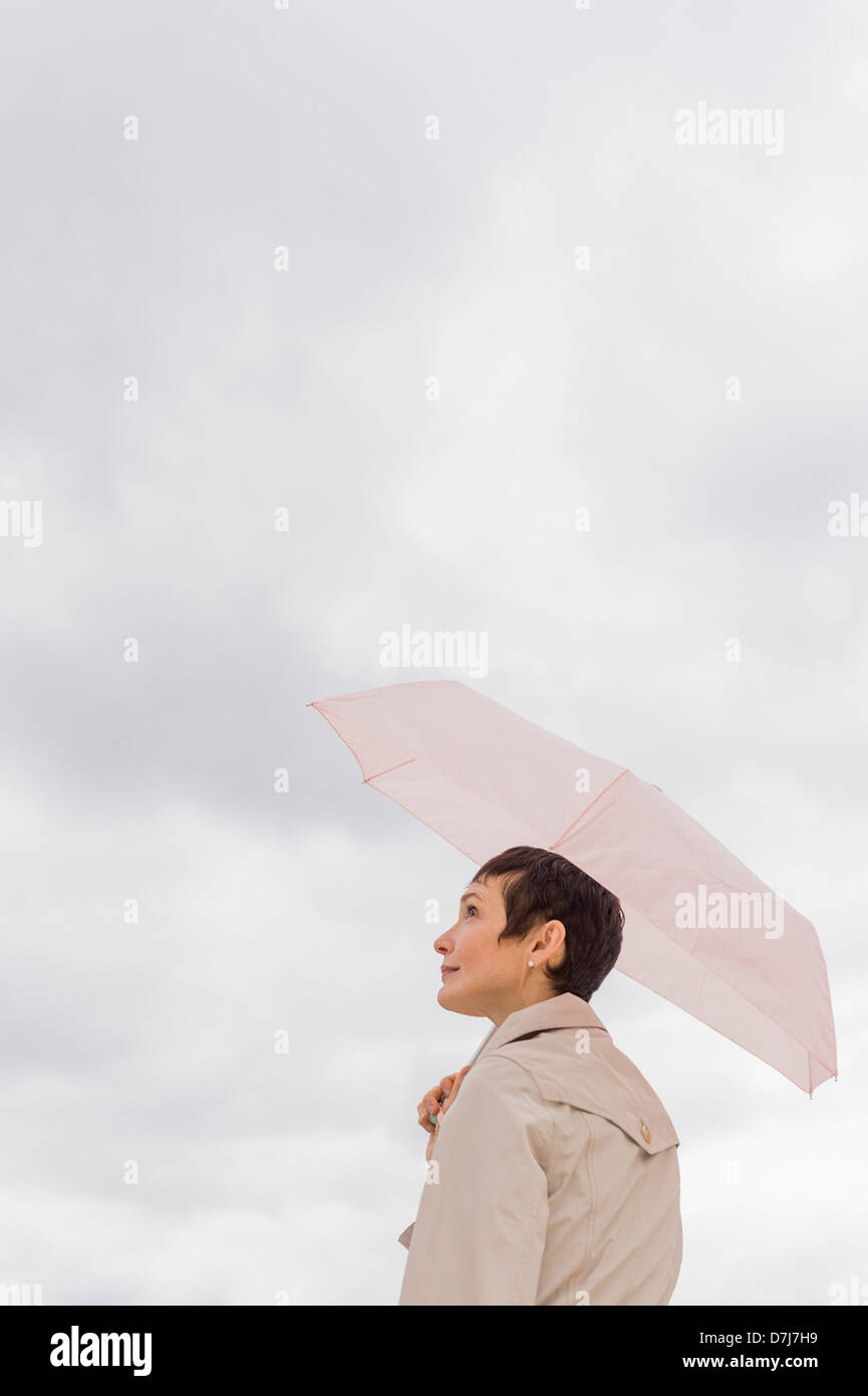 Woman wearing raincoat and holding umbrella Stock Photo