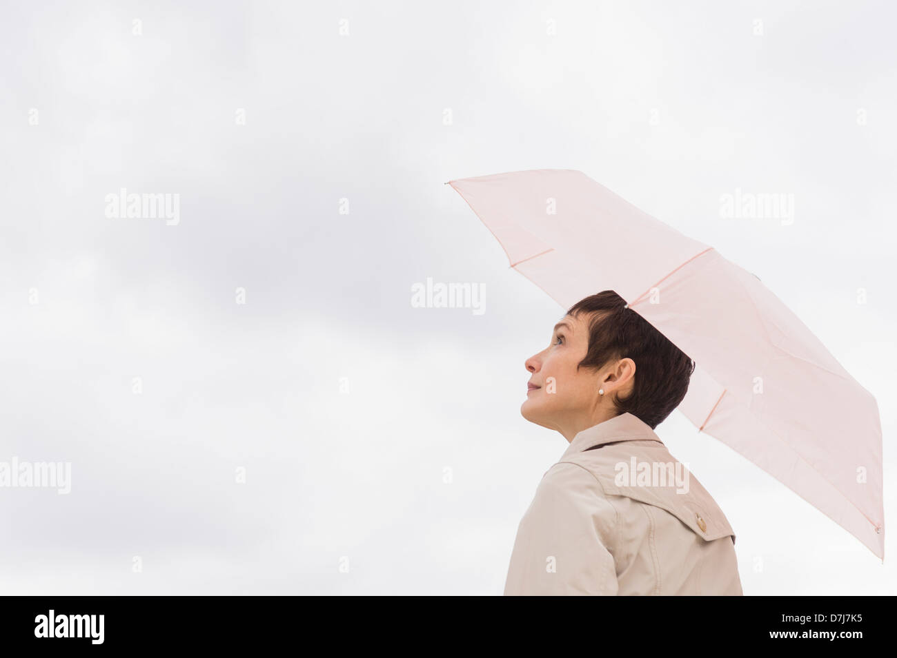Woman wearing raincoat and holding umbrella Stock Photo