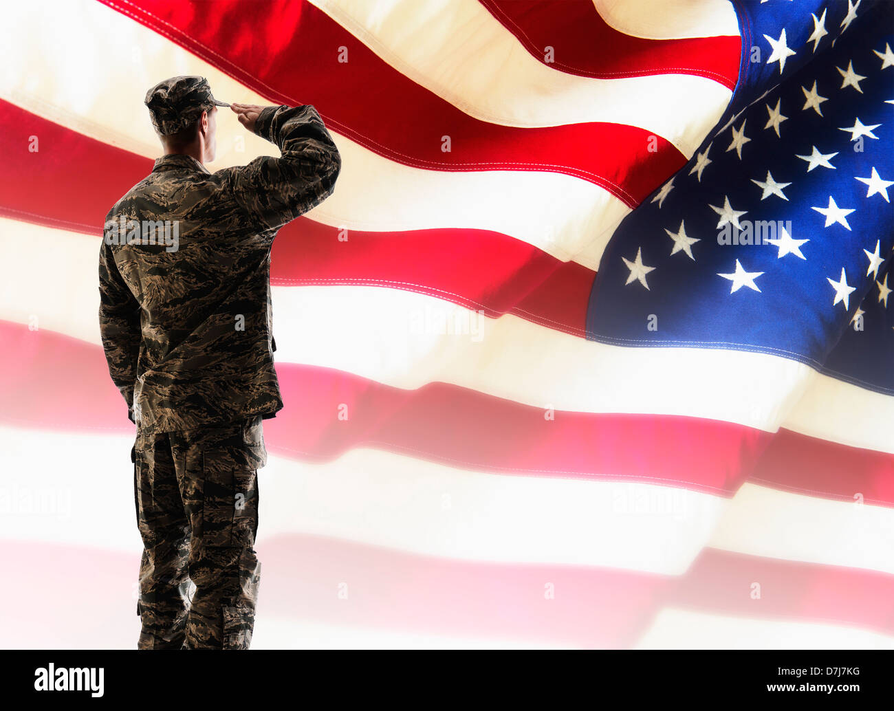 Army soldier saluting in front of American flag Stock Photo