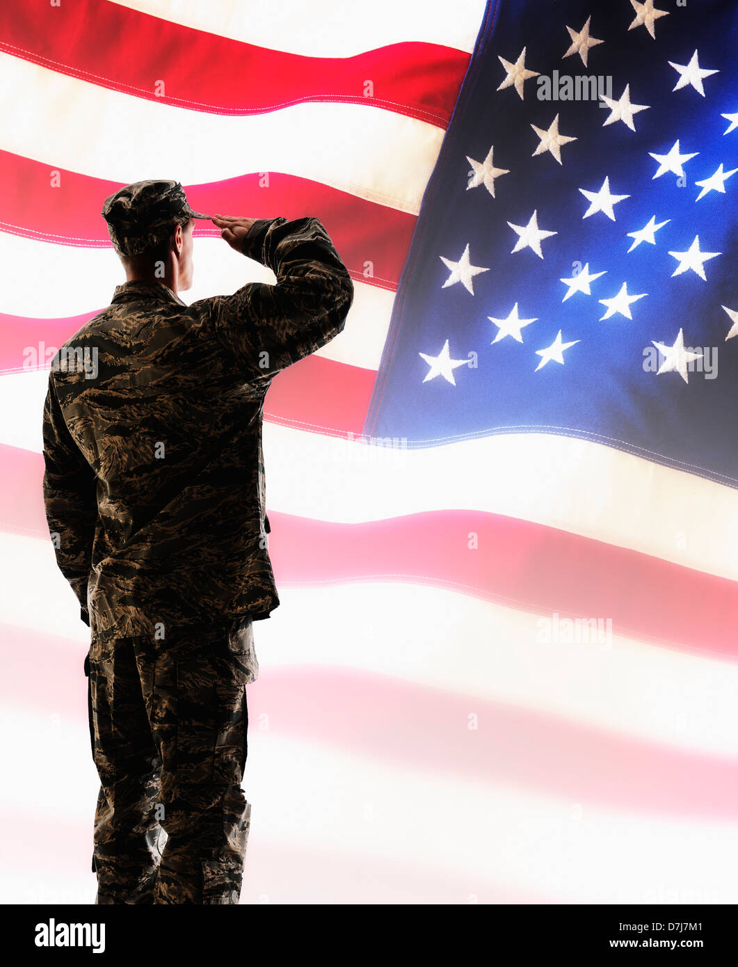 Army soldier saluting in front of American flag Stock Photo