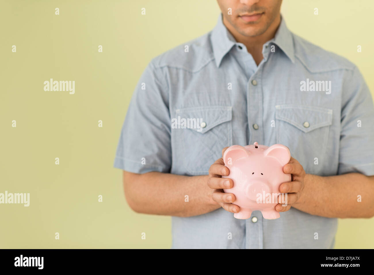 Young man holding piggy bank Stock Photo - Alamy