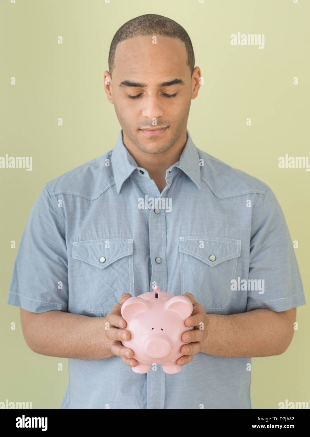Young man holding piggy bank Stock Photo - Alamy