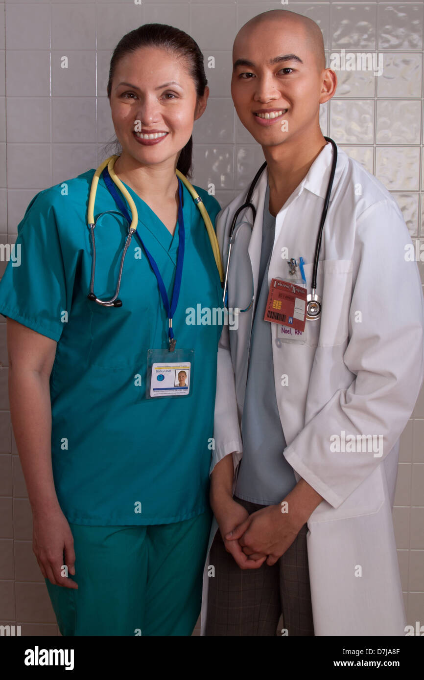 Portrait of two health care professionals smiling, standing in hallway Stock Photo