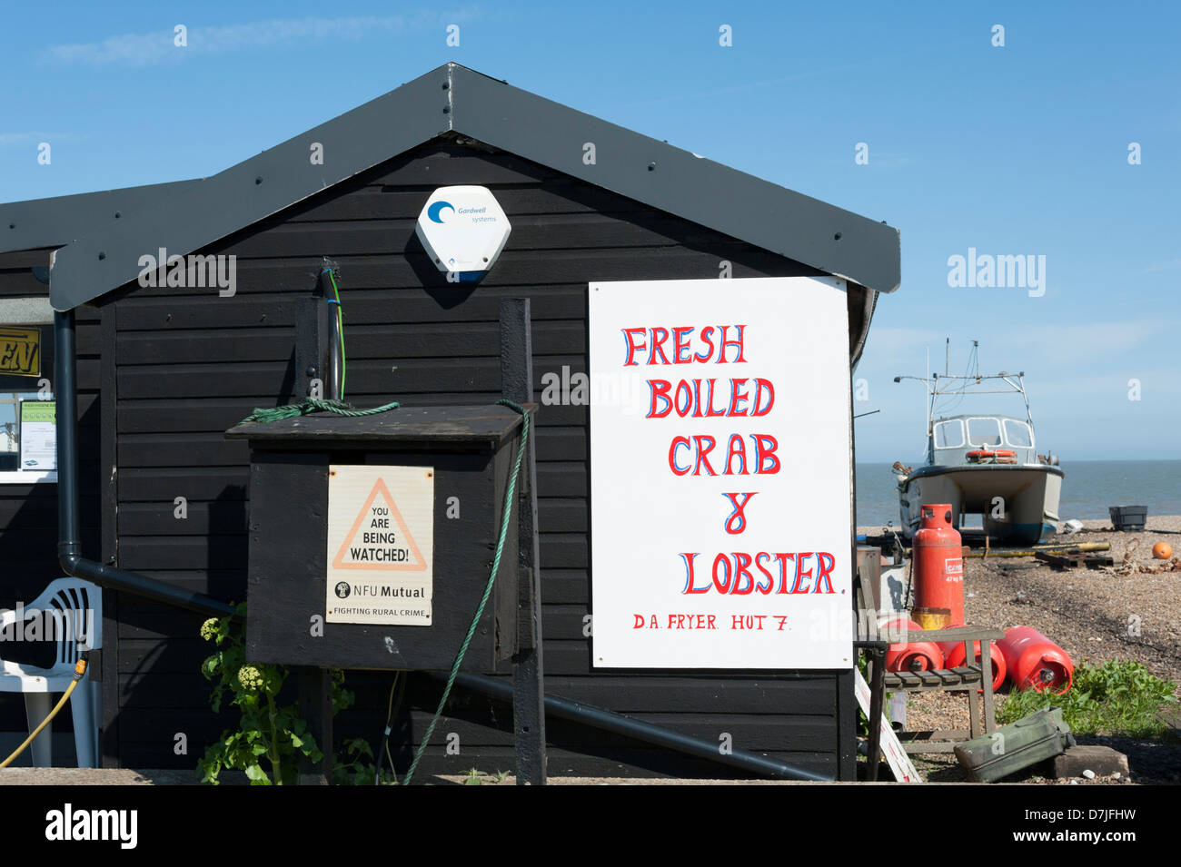 Fish sheds at the beach at Aldeburgh Suffolk UK with signs advertising