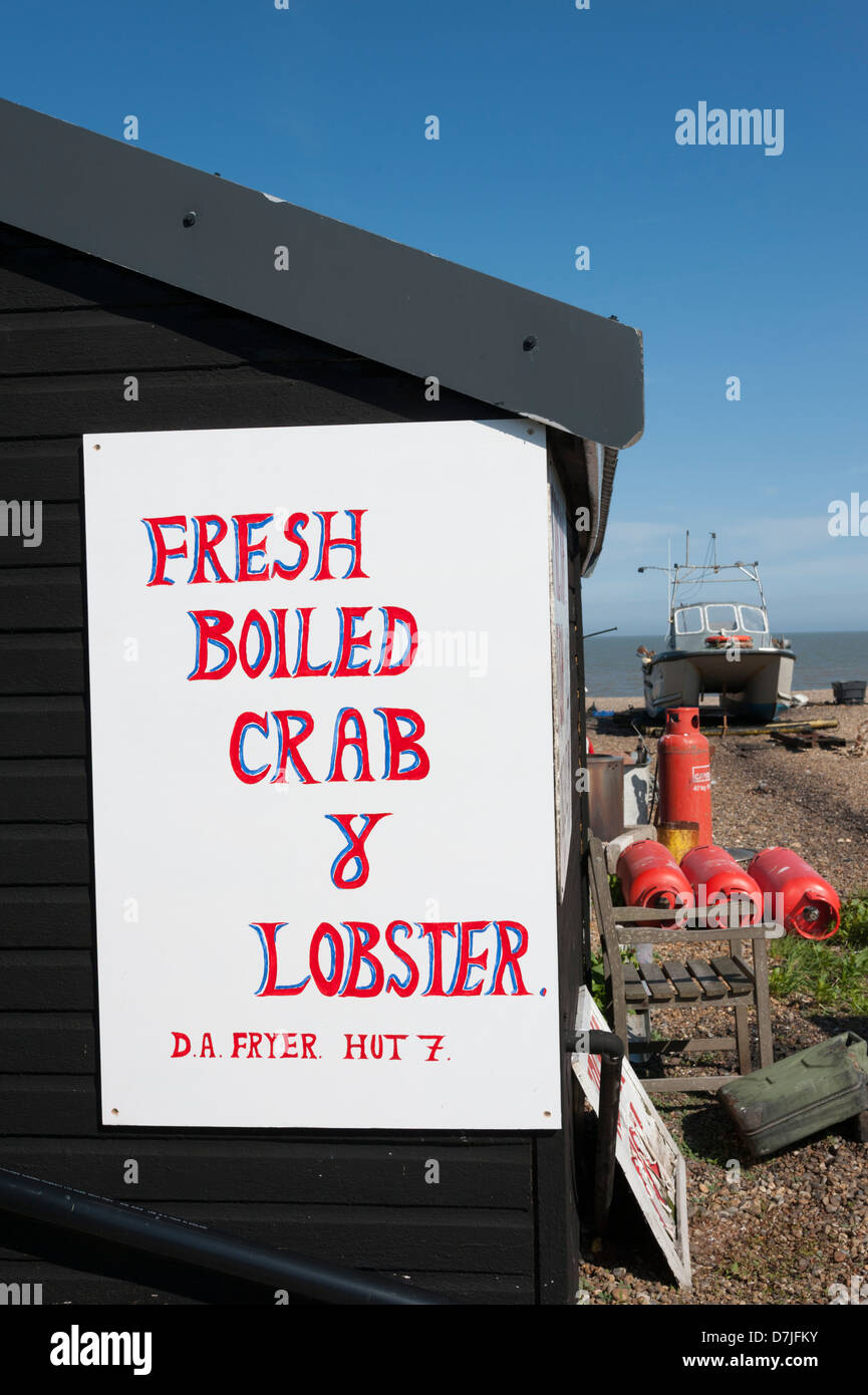 Fish sheds at the beach at Aldeburgh Suffolk UK with signs advertising fresh boiled crabs and lobster Stock Photo