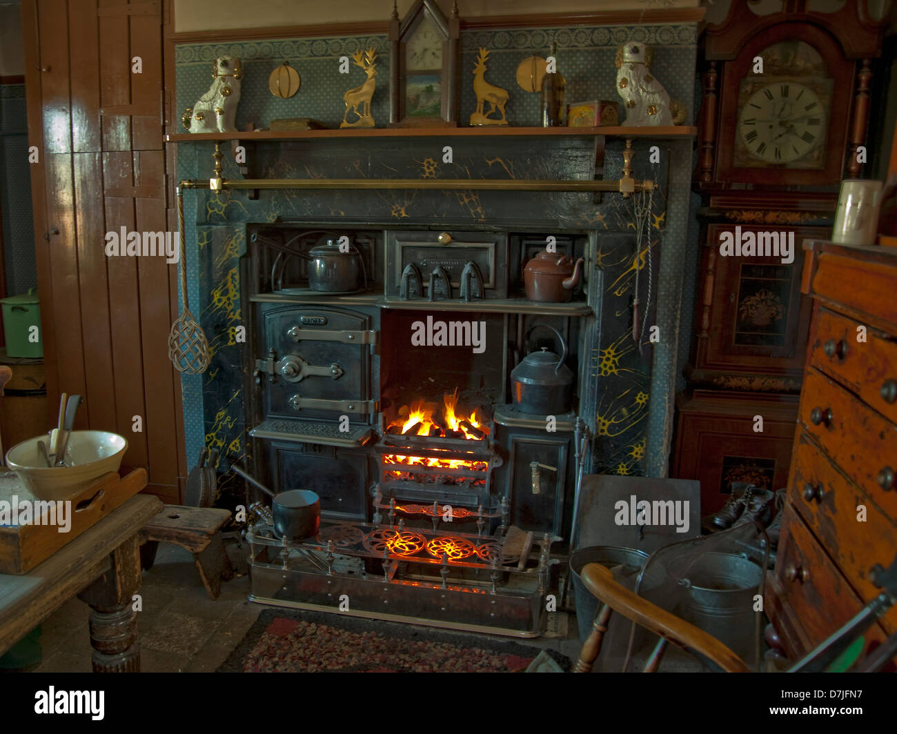 old open fire,old fashioned,ornaments,old fashioned clock.ironwork,chair,oven,pans,pots,kettles Stock Photo