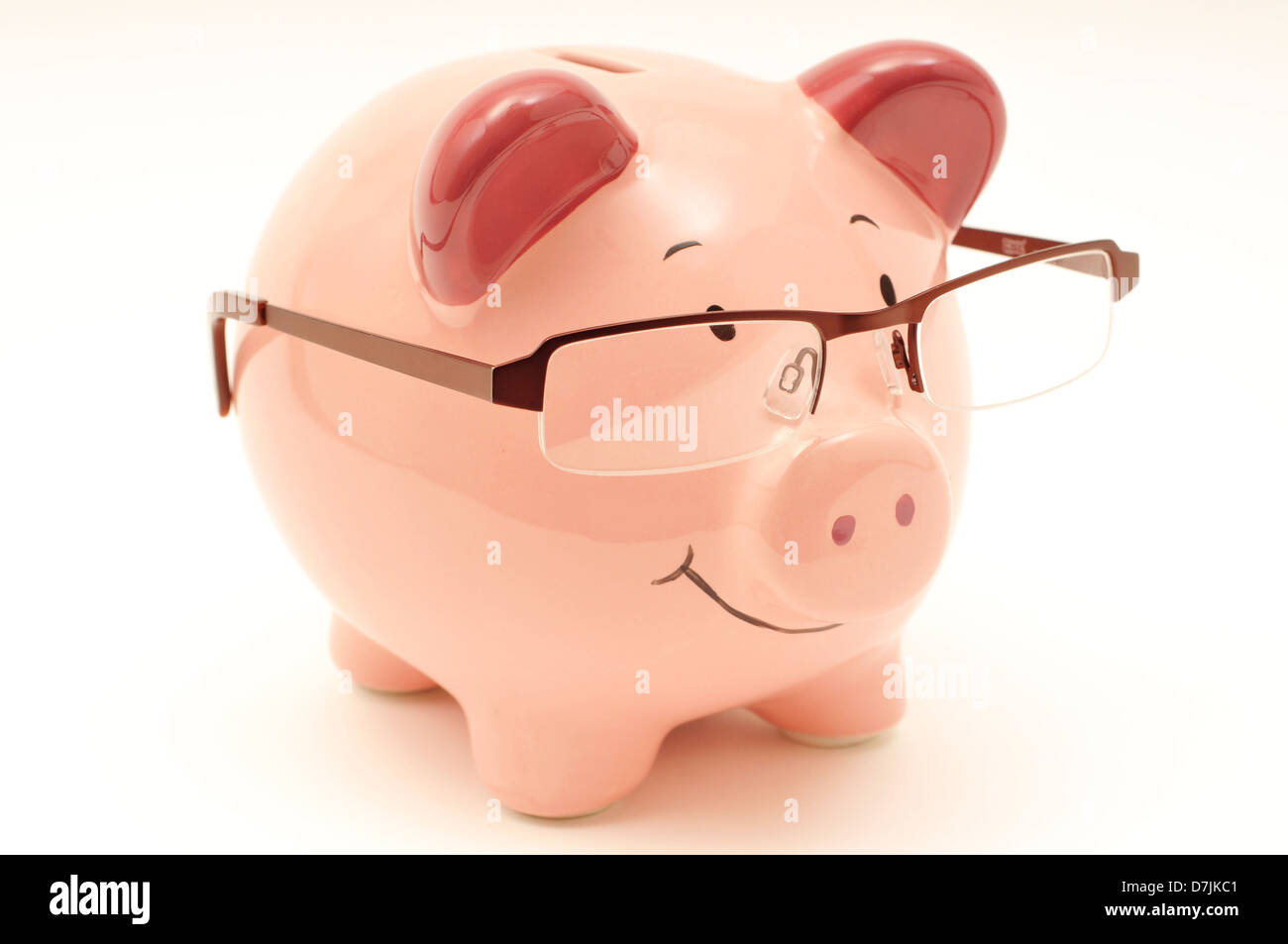 Smiling pink piggy bank wearing glasses against a white background ...