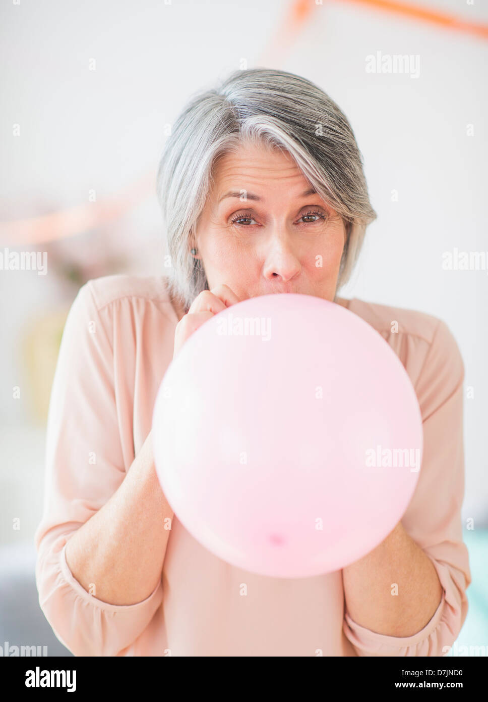 Portrait of woman blowing balloon Stock Photo