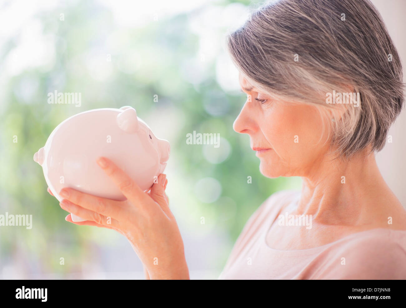 Portrait of woman holding piggy bank Stock Photo - Alamy