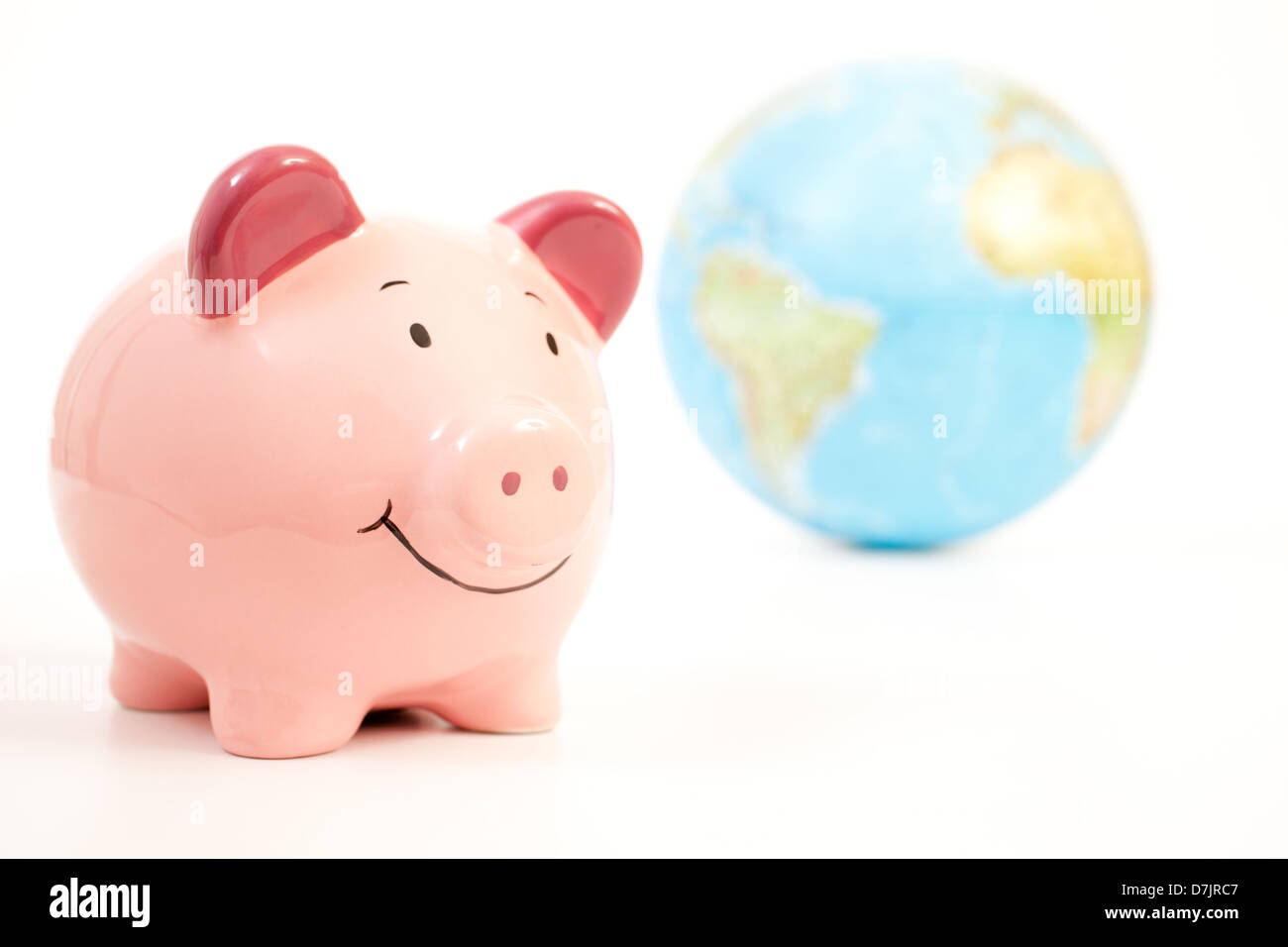 Smiling pink piggy bank with a globe of the world in the background. Stock Photo