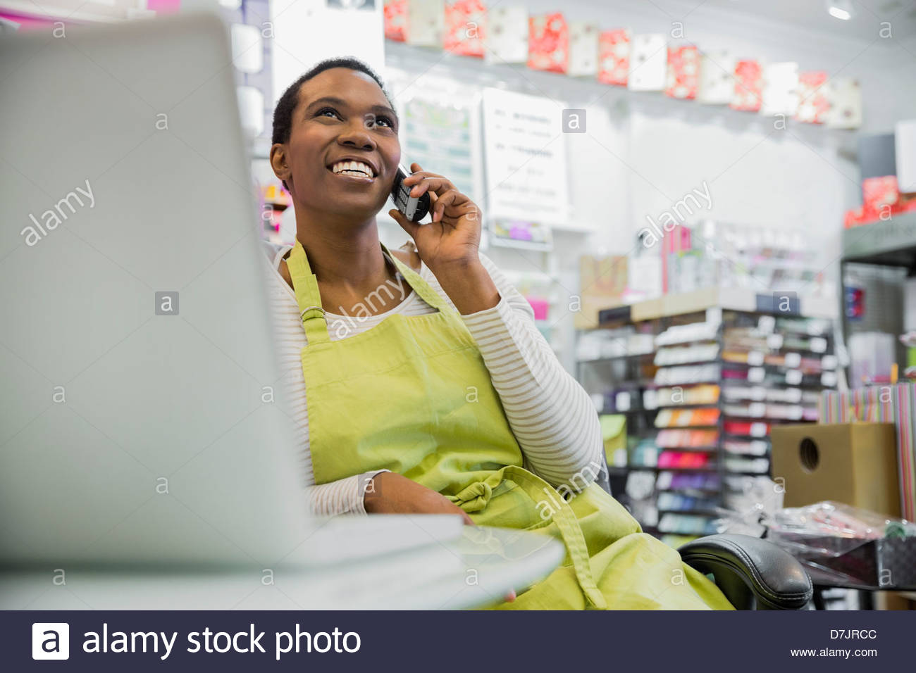 Female small business owner talking on phone in store Stock Photo