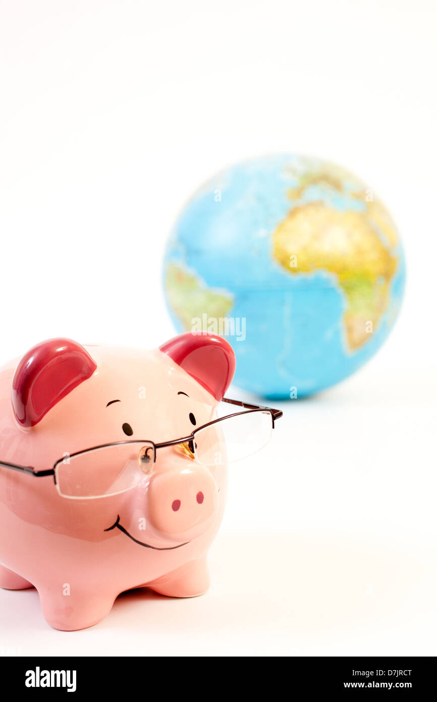 Smiling pink piggy bank with a globe of the world in the background. Stock Photo