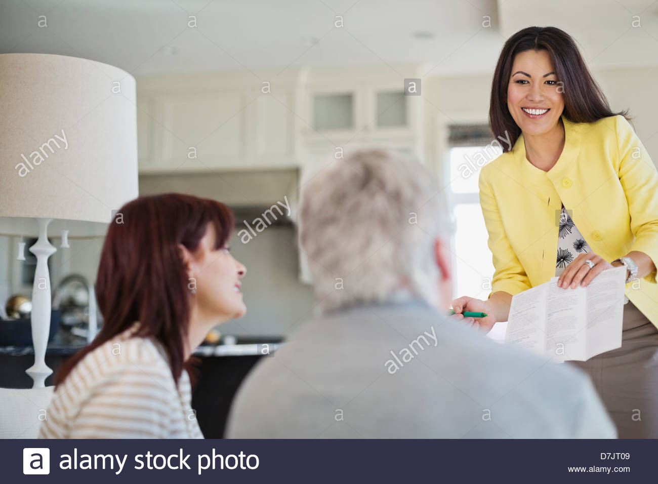 Female financial advisor working with couple in home Stock Photo Alamy