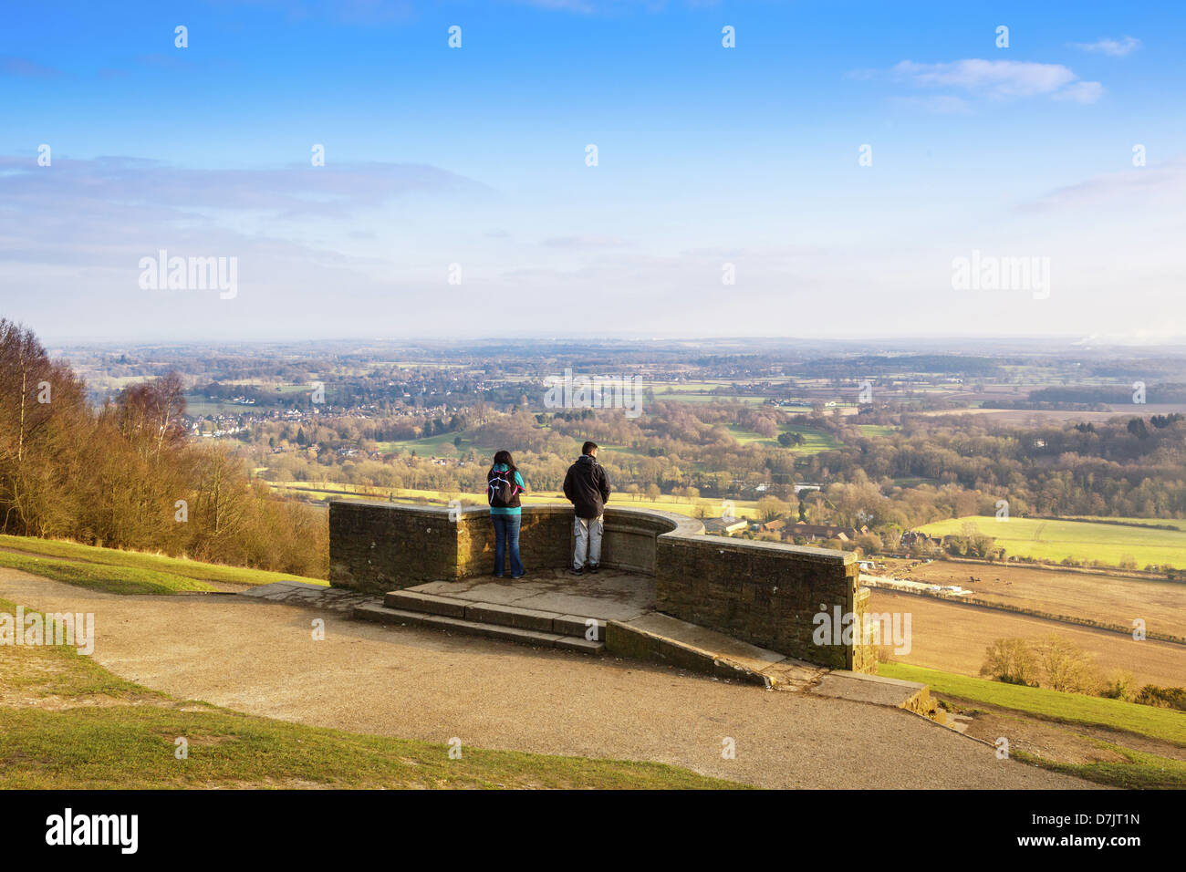 Two people looking at the View across Surrey from the viewpoint on Box hill near Dorking Stock Photo