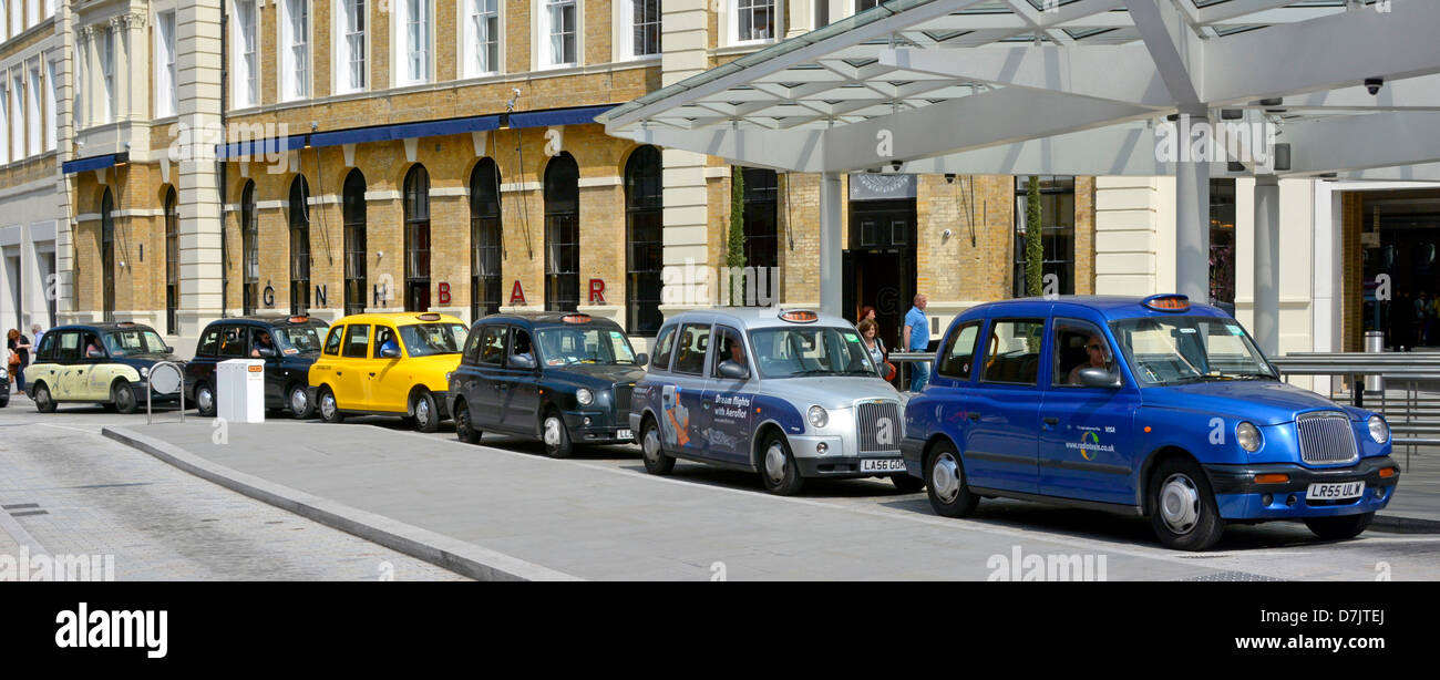 London taxis queuing at taxi rank showing the changing outward appearance of the standard black cab Stock Photo