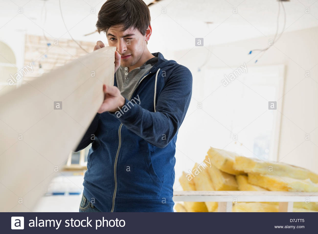 Young man examining lumber at home Stock Photo