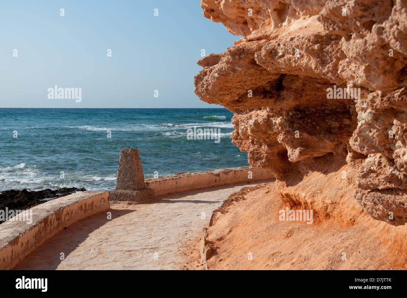 Curved path along the Mediterranean sea with soft rocks. Stock Photo