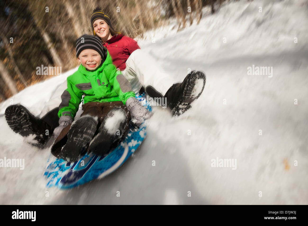 USA, Utah, Highland, Young woman sledding with boy (4-5) Stock Photo