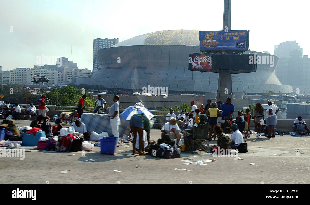 Residents stand outside the damaged Superdome used as a shelter in the aftermath of Hurricane Katrina September 1, 2005 in New Orleans, LA. Stock Photo