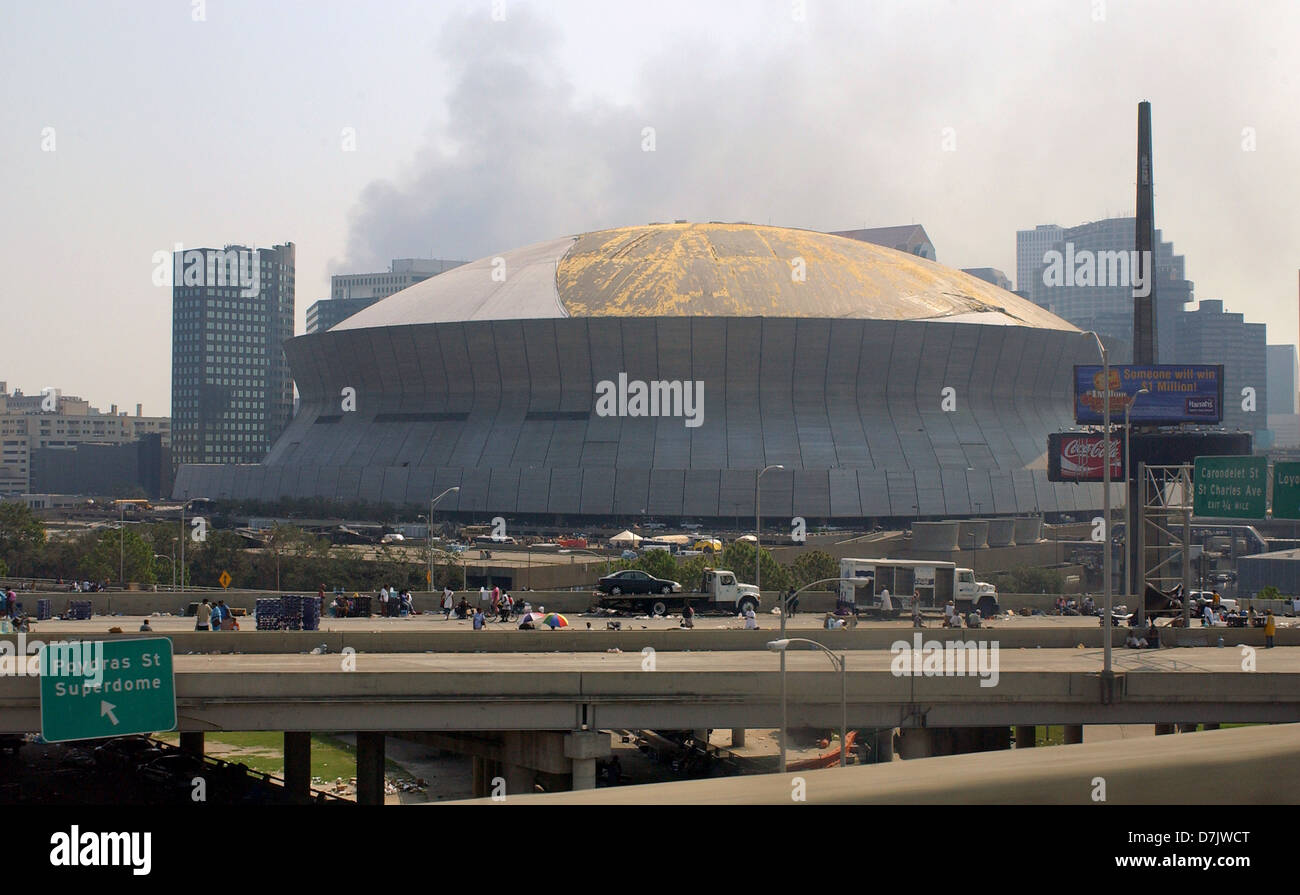 Residents stand outside the damaged Superdome used as a shelter in the aftermath of Hurricane Katrina September 2, 2005 in New Orleans, LA. Stock Photo