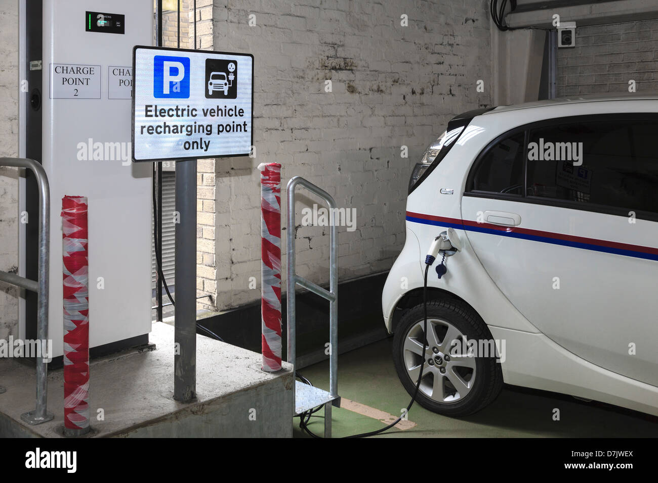 Electric car being recharged with a charging point plug connected into
