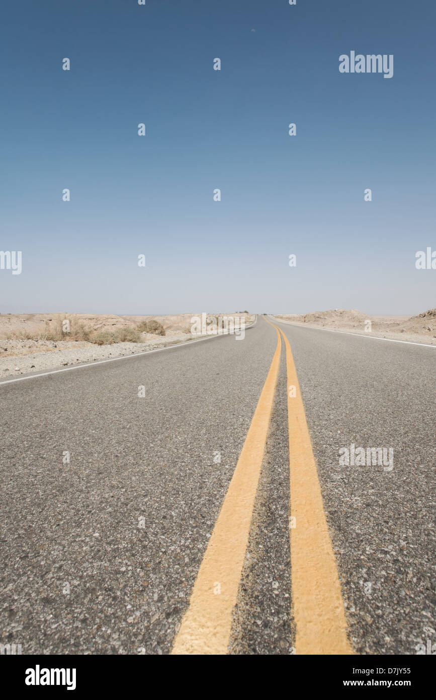 Never ending empty road with dividing yellow lanes in California Stock Photo
