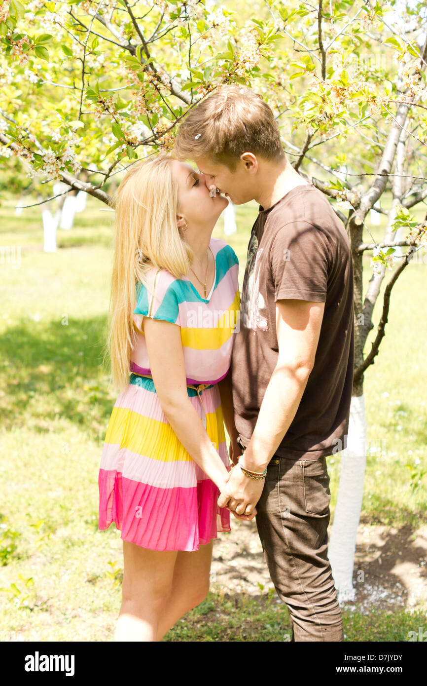 Image of a young romantic couple holding hands and kissing while on an outdoor date. Stock Photo