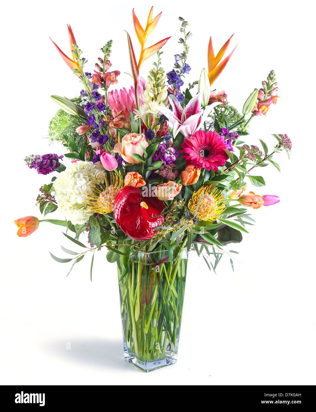 A large flower arrangement in a tall clear glass vase Stock Photo - Alamy