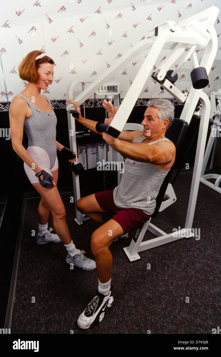 Man working out in gym with Female personal trainer, Miami Stock Photo