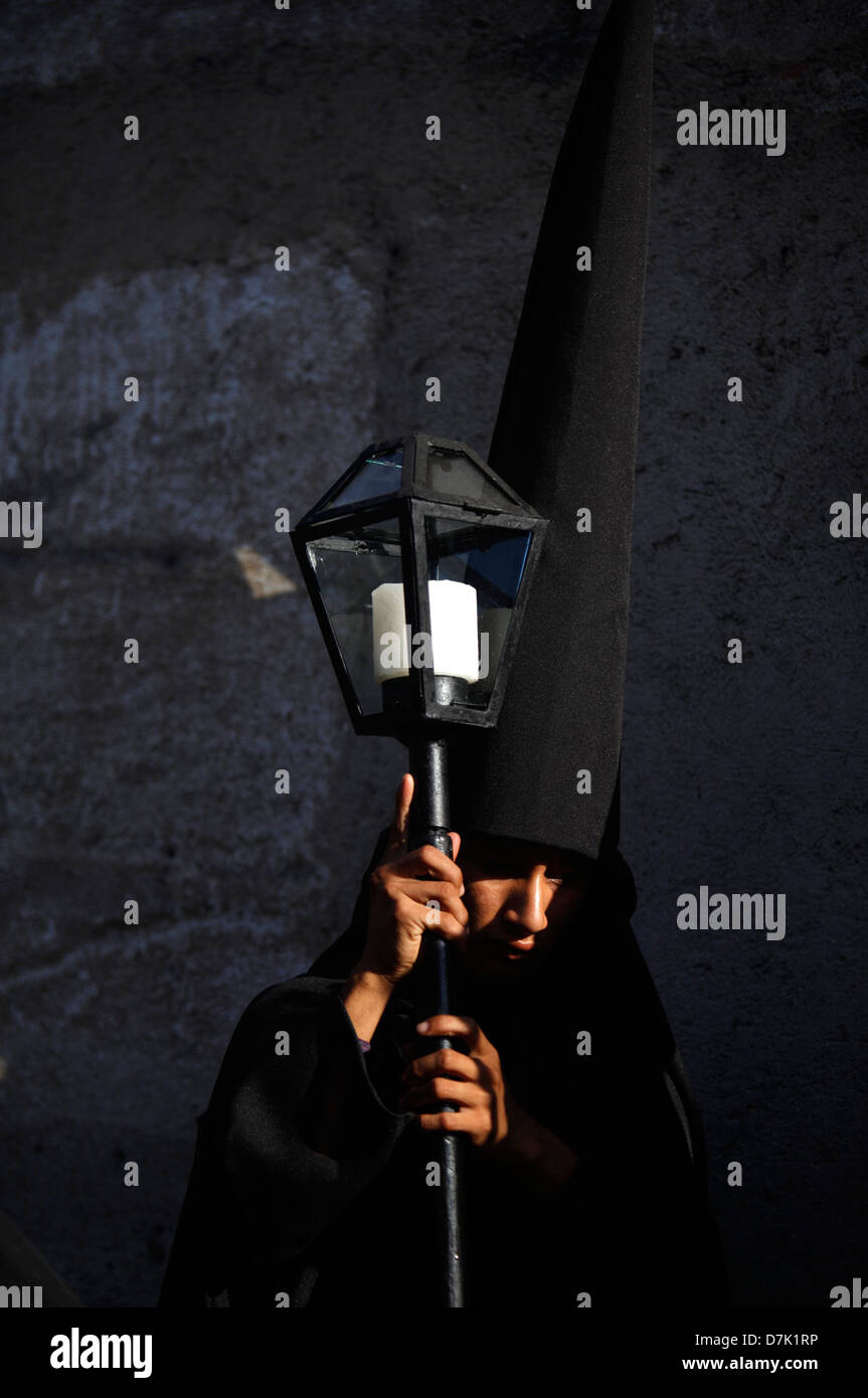 A penitent dressed in black holds a candle during Semana Santa in La Antigua Guatemala, March 29, 2013. Stock Photo